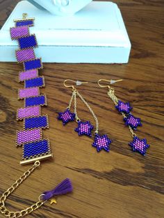 purple and pink beaded bracelets with matching earrings on a wooden table next to a white vase