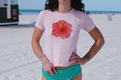 Are you craving that 2000s and 90s nostalgia? We've got you covered with this adorable Hibiscus Flower Baby Tee - bringing your Y2K outfit dreams to life! Our adorable Y2K baby tees will become your new favorite Coconut girl / Mermaidcore shirt from the first wear!  ABOUT THE TEE: - 100% USA cotton (Please note: The Sports Gray variation includes 90% Cotton & 10% Polyester for that authentic touch) - Ribbed knit crew neckline and a convenient tear-away label - Embrace that 90s style with a fit r Pink Hibiscus Print T-shirt For Summer, Pink Hawaiian Short Sleeve T-shirt, Pink Cotton Hawaiian Shirt For Summer, Pink Hawaiian Beach Top, Pink Short Sleeve Hawaiian Shirt For Beach Season, Y2k Style Tops For Beach Vacation, Fitted Casual T-shirt For Beach Season, Pink Hawaiian T-shirt For The Beach, Pink Tropical T-shirt For Spring