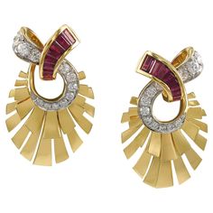 Elegant earrings designed in the shape of a fan and embellished with invisibly-set baguette rubies and round diamonds. Total weight of the rubies is 2.55 carats. 26 round diamonds weighing 2.33 carats total, F-G color, VS clarity. The earrings are mounted in 18k yellow gold. Measurements: 1-3/4 x 1/2 inches. Gross weight: 27.47 grams. Round Diamond Earrings, Retro Glamour, Fan Earrings, Fan Blades, Art Deco Period, Earring Crafts, Cross Jewelry, Ruby Diamond, Mirror Image