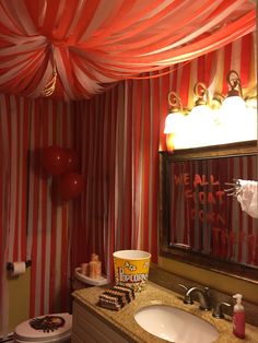 a bathroom decorated with red and white striped walls