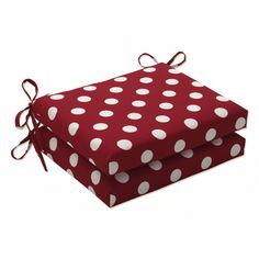 two red and white polka dot cushions with ties on them, one is folded to the side