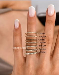 a woman's hand with five rings on her fingers and measurements for each ring