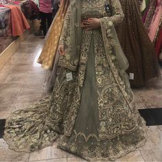 a woman in a green bridal gown posing for the camera