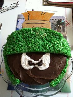 a cake with green frosting and a face on it