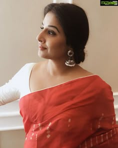 a woman in a red and white sari is looking off to the side with her hand on her hip