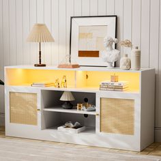 a white and yellow sideboard with lights on it in a room next to a lamp