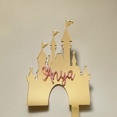 a wooden sign that says enjoy with castle silhouettes in the background and pink lettering on it