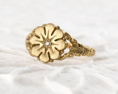 A timeless flower ring modeled after an authentic Victorian antique. DETAILS: Band is 1.75mm wide by 1mm thick Daisy top is 11mm in diameter 1.5mm diamond, ruby or blue sapphire **Choose at checkout Solid 14k yellow, white or rose gold Handmade in Colorado Made to order - Please allow 2-3 weeks for production   Modeled after an authentic Victorian ring, this flower ring design is just as relevant now as it was over one hundred years ago. The ornately-carved details hug close to your finger. The low profile design makes it a breeze to wear everyday. This ring is handmade in solid 14k gold with a flush-set gemstone in the center for a little extra twinkle. This Daisy Ring will be apart of your collection for a lifetime. Wear it as a fashion ring or an alternative engagement ring. Pair it wit Heirloom Rose Cut Diamond Flower Ring As Gift, Heirloom Flower Ring With Rose Cut Diamonds As Gift, Heirloom Diamond Flower Ring In Yellow Gold, Vintage Flower Shaped Diamond Ring, Heirloom Flower Ring With Single Cut Diamonds For Anniversary, Classic 14k Gold Flower Ring With Rose Cut Diamonds, Vintage Yellow Gold Promise Flower Ring, Heirloom Birthstone Ring With Diamond, Vintage Flower Shaped Jewelry With Rose Cut Diamonds