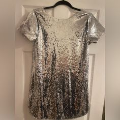 Do Not Miss Out On This Snag! You Will Stand Out And This Dress Is For Sure To Get Many Compliments. This T-Shirt Dress Has So Much Class And Edge To It! Can Dress It Up Or Down. Has A Low Cut Back And Some Cute Cut Outs In The Shoulder! Never Worn. I Love This Dress And Wish It Fit Me The Correct Way! Size Medium Still With Tags! Cocktail Dress With Sequins And Short Sleeves, Metallic Sequin Dress With Contrast Design For Summer, Glamorous Short Sleeve Sequin Dress With Contrast Sequins, Glamorous Short Sleeve Contrast Sequin Dress, Glamorous Short Sleeve Sequin Dress With Contrast, Silver Embellished Sequin Fabric For Night Out, Silver Embellished Sequin Dress For Holiday, Holiday Silver Embellished Sequin Dress, Evening Mini Dress With Contrast Sequin And Short Sleeve