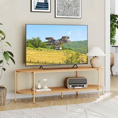 a flat screen tv sitting on top of a wooden entertainment center in a living room