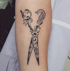 a tattoo on the arm of a woman with scissors in it's middle section