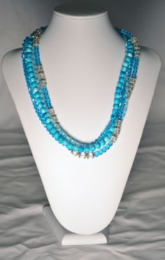 Handmade Beaded Multi Strand Necklace with Turquoise Blue Crystals, Clear Glass Beads and Tonal Turquoise Blue Beads with a Watermark.  Necklace has Silver Accents and a Silver Lobster Claw Clasp.  Necklace Measures 22 Inches Long. Turquoise Beaded Necklaces For Beach With Faceted Beads, Turquoise Faceted Beaded Necklaces For Beach, Turquoise Beaded Necklaces With Gemstone Beads, Turquoise Beaded Necklaces For Beach, Blue Czech Glass Beads For Beach, Turquoise Beaded Czech Glass Necklace, Blue Turquoise Necklace With Polished Beads For Beach, Beach Turquoise Necklace With Polished Beads, Turquoise Czech Glass Round Beads