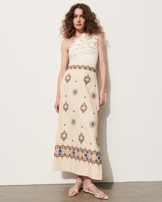 This soft a-line skirt is intricately embroidered in bold blue, rich tan, and soft sand coloring detailing a floral-inspired motif. Complement the high-rise waist with the matching top or a flowy t-shirt. Side-zip closure Length from Highest Point to Hem: 36 1/2" Detailed embroidery throughout Side slits Cotton Poplin Floral Embroidered Flared Dress, Spring Floral Embroidered Maxi Skirt, Chic Floral Embroidery Dress With Flowy Skirt, Chic Dresses With Floral Embroidery And Flowy Skirt, Chic Floral Embroidery Flowy Dresses, Chic Dresses With Floral Embroidery, Beige Floral Print Skirt For Day Out, Chic Floral Embroidered Skirt For Spring, Chic Spring Skirt With Floral Embroidery