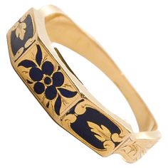 This antique Victorian memory ring is a finely crafted piece, designed in 18-karat gold and adorned with intricate black enamel. The enamel is decorated with a delicate floral design, featuring a "forget-me-not" flower motif. This flower, often associated with remembrance and enduring love, was a popular symbol in Victorian jewelry, adding sentimental and symbolic value to the piece. The outer band of the ring is richly decorated with black enamel, which provides a striking contrast to the warm glow of the gold. The centerpiece of the design is the forget-me-not flower, beautifully rendered in enamel, with its delicate petals symbolizing love, remembrance, and fidelity. The floral design gives the ring a timeless elegance, making it not only a piece of jewelry but also a sentimental keepsa Heirloom Engraved Enamel Ring For Wedding, Heirloom Engraved Enamel Wedding Ring, Heirloom Style Engraved Enamel Wedding Ring, Antique Engraved Yellow Gold Enamel Ring, Heirloom Yellow Gold Engraved Enamel Ring, Antique Yellow Gold Enamel Ring Gift, Antique Yellow Gold Enamel Ring As Gift, Antique Yellow Gold Enamel Ring, Antique Yellow Gold Enamel Ring For Ceremonies