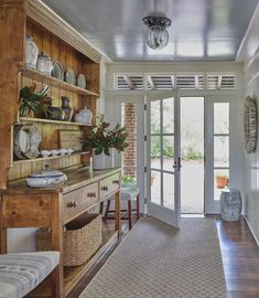 an entry way leading into a home with glass doors and wooden shelves on either side