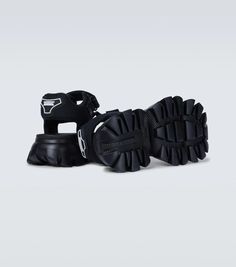 These tank sandals from Prada are made in Italy with woven fabric straps, featuring VELCRO® fastenings, chunky rubber soles, and a rubberized logo at the heel counter..Closure: VELCRO®-fastening ankle strap.Lining: fabric.Made in Italy.Sole: fabric insole, rubber sole.Toe shape: round open toe.Upper: fabric.True to size.Half sizes please take the next size up.UK sizes.6,0cm-2.5' heel (size EU 42) Summer Streetwear Sandals With Rubber Waffle Outsoles, Sport Sandals With Rubber Sole For Streetwear, Modern Sandals With Rubber Sole For Streetwear, Rubber Sole Sport Sandals With Open Toe For Streetwear, Streetwear Sport Sandals With Rubber Sole And Open Toe, Open Toe Sport Sandals With Rubber Sole For Streetwear, Sporty Nylon Sport Sandals With Rubber Sole, Casual Black Sandals With Logo Strap, Nylon Sandals With Rubber Sole And Round Toe