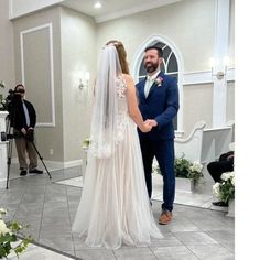 a bride and groom standing in front of the alter