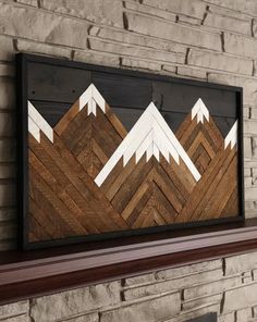 a fireplace mantel topped with a wooden wall art