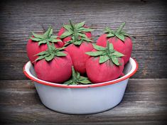 a bowl filled with red strawberries on top of a wooden table