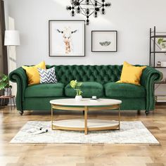 a living room with green couches and pictures on the wall above them, along with a coffee table