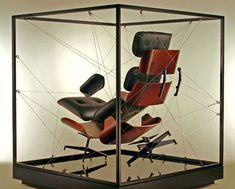 an office chair in a glass case on display