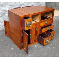 an old wooden desk with drawers on the bottom and one drawer open to show what's inside