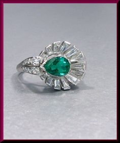 Set in platinum and dating from the 1940's, this distinctively shaped retro ring holds a 1.25 ct vividly green pear shaped Columbian emerald and is enveloped by 1.50 ct of shimmering tapered baguettes and round diamonds, all set east to west, for a waterfall of intense beams of luminescence. R 308S SIX MONTH LAY-AWAY AVAILABLE - PLEASE CONTACT ME TO SET UP A PLAN Gia Certified Green Diamond Ring In Vintage Style, Vintage Green Emerald Ring Gia Certified, Vintage Green Diamond Platinum Ring, Vintage Green Diamond Ring In Platinum, Vintage Green Emerald Ring With Brilliant Cut, Gia Certified Green Pear-shaped Diamond Ring, Vintage Green Diamond Ring With Center Stone, Classic Pear-shaped Green Ring, Classic Green Pear-shaped Ring