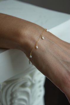 A dainty and minimal chain bracelet with tiny freshwater pearl dangles. Looks amazing layered or on it's own. Closure: spring ring clasp Materials: 14K Gold Filled or Sterling Silver Measures approx. adjustable Handmade in New York Arrives perfectly packaged, ready for gift-giving! Other jewelry shown is for styling purposes only and sold individually Dainty Silver Bracelets, Bridal Jewelry Bracelets, Snapchat Icon, Circle Outline, Styles P, Dainty Bracelet, Bag Icon, Jewelry Show, Dainty Bracelets