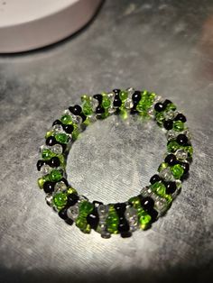 This clear, black and green beaded bracelet is fun for everyone! Great for parties, concerts and more! Green Beaded Bracelets With Black Beads As A Gift, Handmade Green Plastic Beaded Bracelets, Adjustable Green Plastic Beaded Bracelets, Green Bracelets With Colorful Glass Beads, Green And Black Bracelet, Black Beaded Bracelet, Green Beaded Bracelets, Black Beaded Bracelets, Plastic Resin