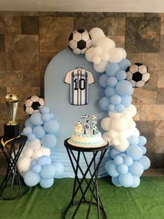 a soccer themed birthday party with balloons, cake and t - shirt on the table