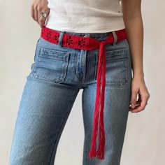 a woman in jeans with a red belt around her waist