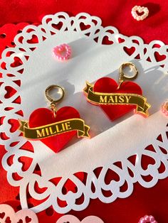 CUSTOM earrings - up to 10 characters. Could be a name or a short phrase. Earrings could match or be two different names. All letters are CAPITALIZED. Write what you would like on both earrings in the note for seller. Please DOUBLE CHECK your spelling. Choice of gold or silver banners. Hardware will match banner. Red pearlescent acrylic for the hearts. ♥️ Hypoallergenic gold plated brass hooks. Acrylic and lightweight. Personalized Heart Earrings For Birthday, Custom Name Earrings For Valentine's Day Gift, Custom Name Gold Earrings For Valentine's Day, Heart-shaped Earrings For Valentine's Day Birthday, Custom Name Earrings For Mother's Day Gift, Heart-shaped Earrings For Birthday And Mother's Day, Personalized Heart Earrings For Valentine's Day, Personalized Name Earrings For Mother's Day, Personalized Heart Earrings For Mother's Day