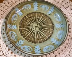 a bowl on a doily with blue and white designs