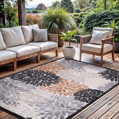 a living room area with couches, chairs and rugs on the wooden floor