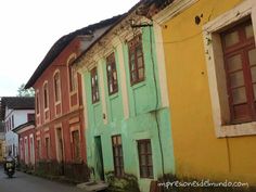 an old street lined with colorful buildings in different colors and styles, including green, yellow, red, blue, and pink