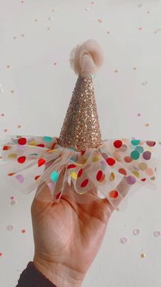 a hand is holding a small party hat