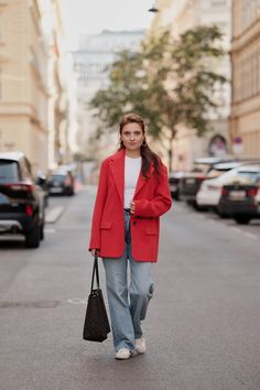 Red single-breasted wool jacket featuring a relaxed fit, with a classic collar and lapels, long rolled-up sleeves, and front patch pockets with flaps. Secured with two buttons. This design is inspired by the 'men's shoulder' style, adding a touch of masculinity to your look. Not only is it on-trend, but it also serves as a versatile base for any outfit. The jacket's generous cut and wide shoulders make it perfect for layering oversized sweatshirts or sweaters underneath, allowing for comfortable movement. Model measurements: Height - 175 cm (5'9"ft) Bust - 82 cm (32.3 in) Waist - 61 cm (24 in) Hips - 92 cm (36.2 in) 🧶Details 40% Wool, 40% Acrylic, 20% Polyamide Lining: Viscose Model wears a size S 📏Product Size Chart: S (US 4-6) 1/2 Bust - 52 cm | 20.4 in 1/2 Hip - 52 cm | 20.4 in Back L Red Wool Blazer Outfit, Red Coat Outfit, Red Blazer Outfit, Red Rain Jacket, Shoulder Jacket, Wide Shoulders, Red Flare, Straight Jacket, Short Women