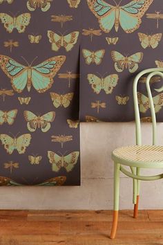 a chair sitting next to a wall with butterflies on it