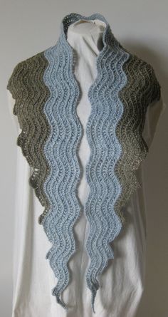 a white shirt with blue and green crochet on it