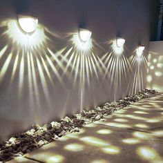 several spotlights are shining on the wall with rocks and stones in front of them