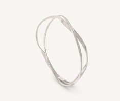 An 18K white gold twisted thread, carefully crafted with our exclusive coil technique, intertwines with a white gold thread embellished with brilliant-cut diamonds. With its sophisticated design, this bangle bracelet can be worn alone or stacked with more bangles for a mix and match effect. Luxury Flexible Silver Bangle, Elegant Silver Spiral Bangle, Elegant Twisted Silver Bracelets, Elegant Silver Twisted Bracelet, White Gold Spiral Jewelry For Formal Occasions, Formal Spiral White Gold Jewelry, Formal White Gold Spiral Jewelry, Elegant Spiral Sterling Silver Bracelets, Elegant Twisted Jewelry With Polished Finish