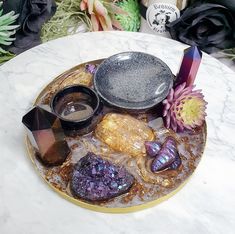 a plate with some rocks and flowers on it