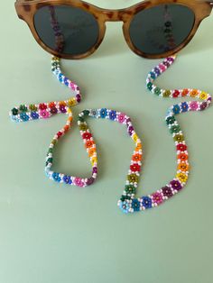 sunglasses and beads are laid out on the table to be used as an art project