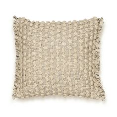 a beige pillow with tassels on the front and back, against a white background