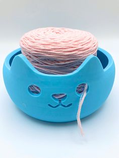 a blue cat shaped bowl with yarn in it