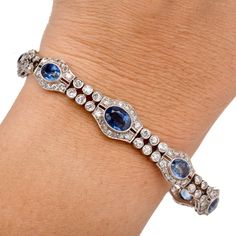 Walser Wald Vintage Deco Diamond Sapphire Platinum Bracelet Presenting a gorgeous Vintage Art Deco Bracelet crafted in Platinum with Natural Diamonds and Sapphires. In a two-row Oval link Design the gemstone and Diamonds are bezel and Prong set to perfection.  It is secured with an Insert clasp and a chain with a spring ring. Diamond total Carat weight approx: 5.70 cttw Clarity Grade approx: F-G Color Grade approx: VS2-SI1 Set with nine bezel-set sapphires, weighing approx: 14.50  cttw Bracelet Elegant Multi-stone Oval Tennis Bracelet, Elegant Oval Multi-stone Tennis Bracelet, Elegant Diamond Multi-stone Bracelets, Elegant Multi-stone Diamond Bracelets, Elegant Multi-stone Diamond Bracelet, Elegant Multi-stone Sapphire Bracelet, Elegant Sapphire Multi-stone Bracelet, Elegant Multi-stone Round Diamond Bracelet, Elegant Multi-stone Round Tennis Bracelet