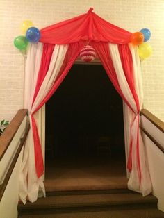 an entrance to a party with balloons on the ceiling and drapes over the door