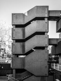 black and white photograph of stairs in front of an apartment building with multiple balconies