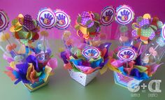 three vases filled with colorful paper flowers on top of a table