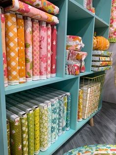 the shelves are filled with colorful fabrics and quilting material, all in different colors